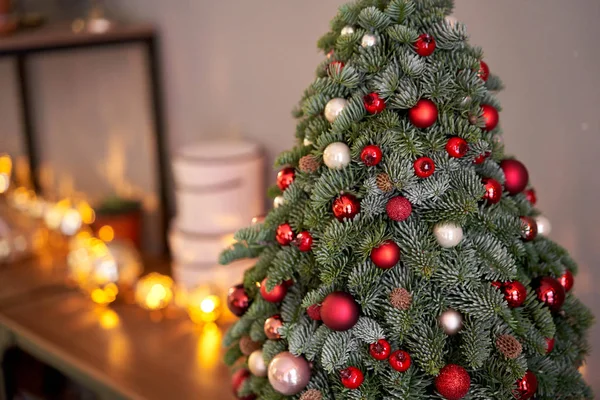 Bela árvore de Natal pequena na mesa de madeira. Bom humor. Lâmpada de guirlanda bokeh no fundo. Papel de parede. Pinheiro e abeto dinamarqueses, Nobilis — Fotografia de Stock