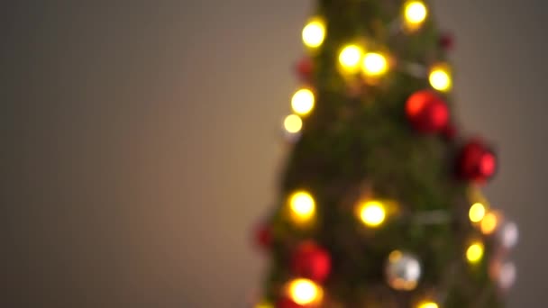 Hermoso pequeño árbol de Navidad de musgo en la mesa de madera. Feliz humor. Lámpara de guirnalda bokeh sobre fondo. Desenfoque abstracto . — Vídeos de Stock