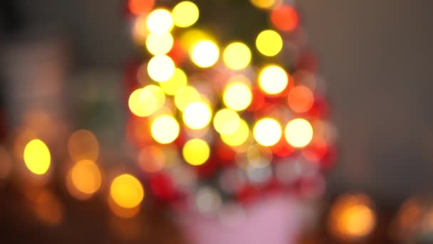 Bela pequena árvore de Natal de musgo na mesa de madeira. Bom humor. Lâmpada de guirlanda bokeh no fundo. Desfoque abstrato . — Vídeo de Stock