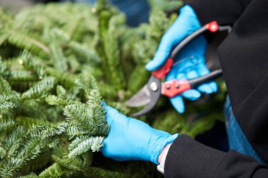 Bir kadın Noel düzenini süslüyor. Dekoratif süsler konusunda yüksek lisans. Noel dekorunu kendi elleriyle yaptılar. Yeni yıl kutlaması. Çiçekçi