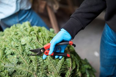 Bir kadın Noel düzenini süslüyor. Dekoratif süsler konusunda yüksek lisans. Noel dekorunu kendi elleriyle yaptılar. Yeni yıl kutlaması. Çiçekçi