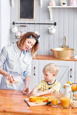 Anne ve oğul mutfakta bir kahvaltı yaparken gülümsüyorsun. Anne süt cam içine yağıyor