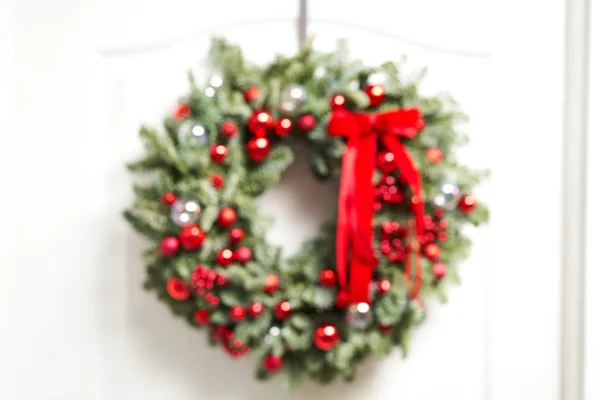 Αφηρημένη θολούρα. Κοντινές λεπτομέρειες του πανέμορφου Χριστουγεννιάτικου στεφανιού από φρέσκο έλατο στη λευκή πόρτα. Είσοδος στο σπίτι. Χριστουγεννιάτικη διάθεση. Χριστουγεννιάτικο δέντρο. — Φωτογραφία Αρχείου