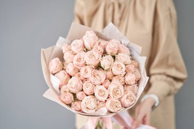 Tek demet sprey gül. Kadınların elinde zarif bir buket karışık çiçek. Çiçekçi dükkanındaki çiçekçinin işi. Hassas Pastel rengi. Taze kesilmiş çiçek..