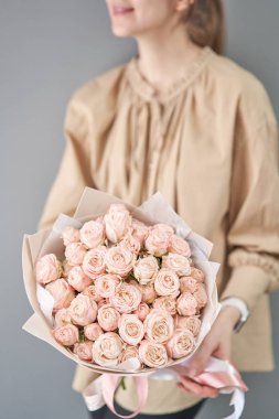 Tek demet sprey gül. Kadınların elinde zarif bir buket karışık çiçek. Çiçekçi dükkanındaki çiçekçinin işi. Hassas Pastel rengi. Taze kesilmiş çiçek..