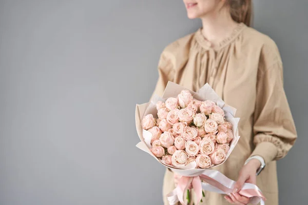Buchet de trandafiri cu pulverizare. Buchet delicat de flori mixte în mâinile femeilor. Lucrarea florarului la un magazin de flori. Culoare delicată Pastel. Floare proaspăt tăiată . — Fotografie, imagine de stoc