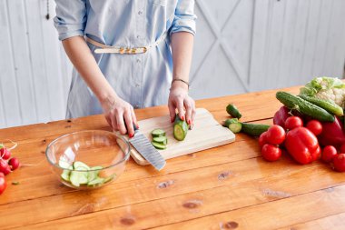 Güzel genç bayan mutfakta sebze salatası hazırlıyor. Sağlıklı yiyecekler. Evde yemek pişirmek. Diyet Konsepti.
