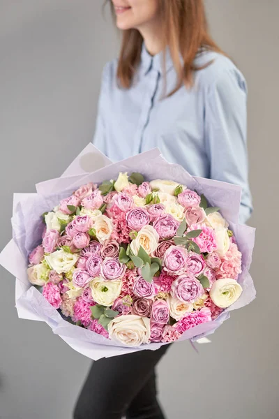 Loja floral europeia. Belo buquê de flores mistas em mãos de mulheres. o trabalho da florista em uma loja de flores. Entrega flor de corte fresco . — Fotografia de Stock