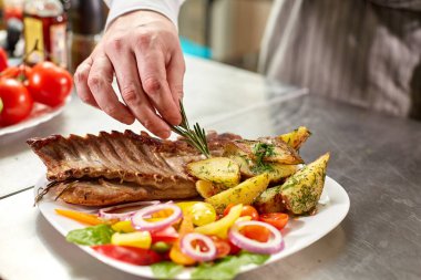 rosemary bir delikanlı ile dekore edilmiştir. Şef restoranda hazırlar. Taze sebze ve patates kızartması ile kuzu ızgara raf