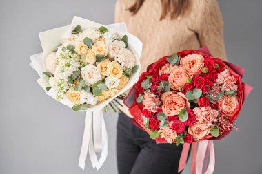 Kadınların elinde iki buket karışık çiçek var. Çiçekçi dükkanındaki çiçekçinin işi. Taze kesilmiş çiçek getirdim. Avrupa Çiçek Dükkanı.