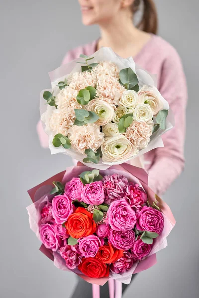 Two Beautiful bouquets of mixed flowers in womans hands. the work of the florist at a flower shop. Delivery fresh cut flower. European floral shop. — Stock Photo, Image