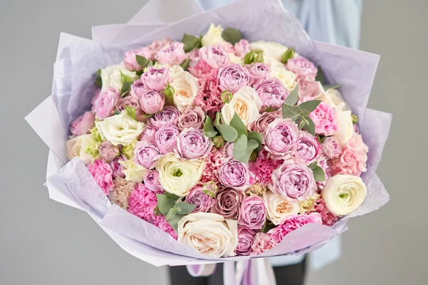 Europäischer Blumenladen. Schöner Strauß gemischter Blumen in Frauenhänden. die Arbeit des Blumenhändlers in einem Blumenladen. Lieferung frischer Schnittblumen. — Stockfoto