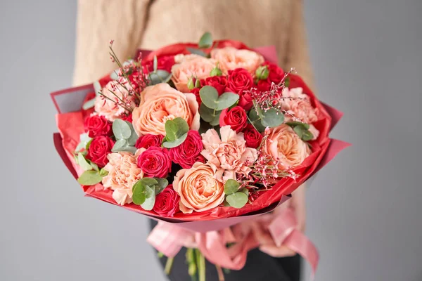 European floral shop. Beautiful bouquet of mixed flowers in womans hands. the work of the florist at a flower shop. Delivery fresh cut flower. — Stock Photo, Image