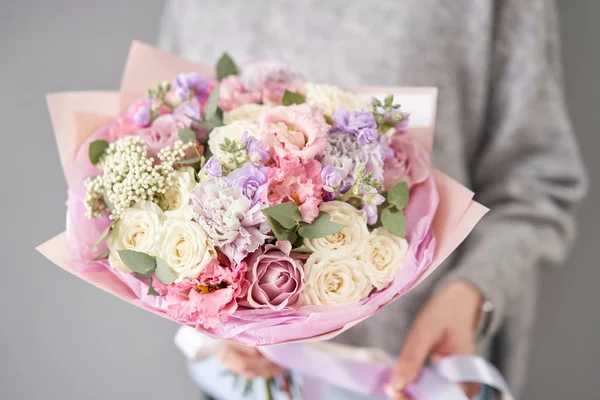 European floral shop. Beautiful bouquet of mixed flowers in womans hands. the work of the florist at a flower shop. Delivery fresh cut flower. — Stock Photo, Image