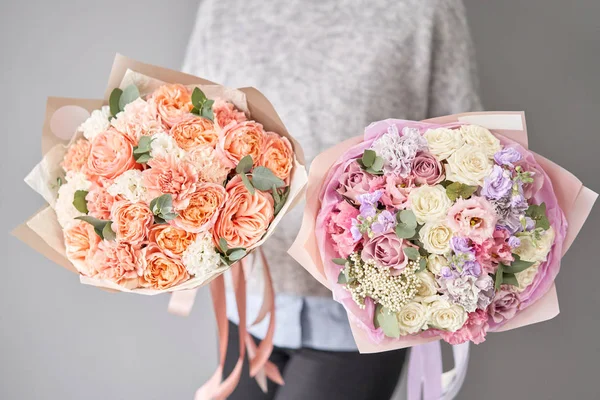 Zwei schöne Sträuße gemischter Blumen in Frauenhänden. die Arbeit des Blumenhändlers in einem Blumenladen. Lieferung frische Schnittblume. Europäischer Blumenladen. — Stockfoto