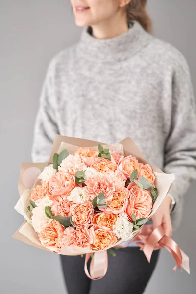 Tienda floral europea. Hermoso ramo de flores mixtas en manos de mujeres. el trabajo de la floristería en una florería. Entrega flor fresca cortada . — Foto de Stock