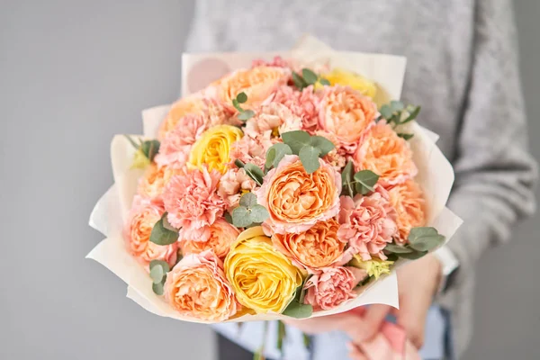 Europese bloemenwinkel. Mooi boeket van gemengde bloemen in vrouwen handen. het werk van de bloemist in een bloemenwinkel. Levering verse snijbloem. — Stockfoto