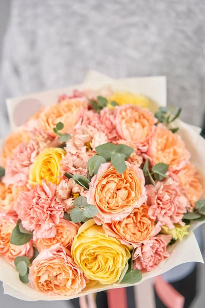 European floral shop. Beautiful bouquet of mixed flowers in womans hands. the work of the florist at a flower shop. Delivery fresh cut flower. — Stock Photo, Image