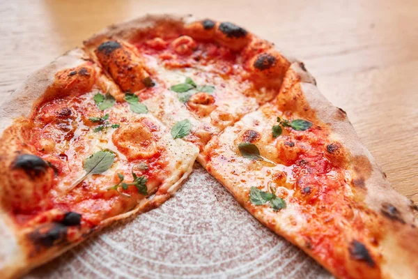 Pizza Margarita. Baked tasty margherita pizza in Traditional wood oven in Neapolitan restaurant, Italy.