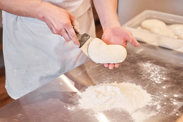 Pasta per pizza napoletana, lo chef tira fuori gli spazi vuoti. Primo piano mano dello chef panettiere in uniforme grembiule bianco cucinare la pizza in cucina — Foto Stock