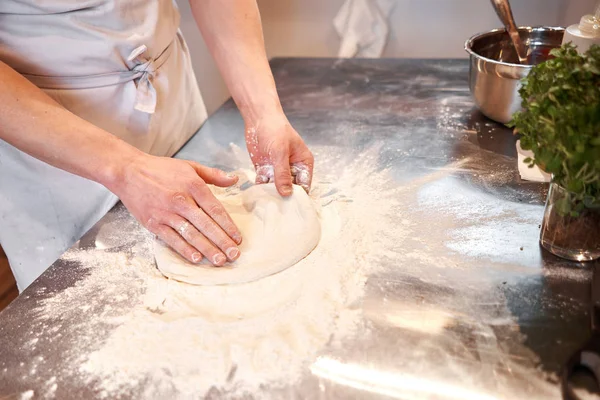 Бабки за неаполитанскую пиццу, шеф-повар выкатывает холостые. Рука повара-пекаря в форме белого фартука готовит пиццу на кухне — стоковое фото