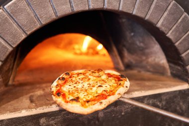 Napoli restoranında geleneksel ahşap fırında margherita pizza pişirdim. Orijinal Napoli pizzası. Kırmızı sıcak kömür.
