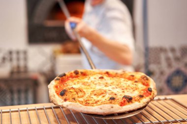 Napoli restoranında geleneksel ahşap fırında pişmiş margherita pizza. Orijinal Napoli pizzası. Kırmızı sıcak kömür.