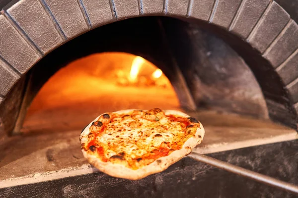 Gustosa pizza margherita al forno nel tradizionale forno a legna del ristorante napoletano. Pizza napoletana originale. Carbone caldo rosso . — Foto Stock