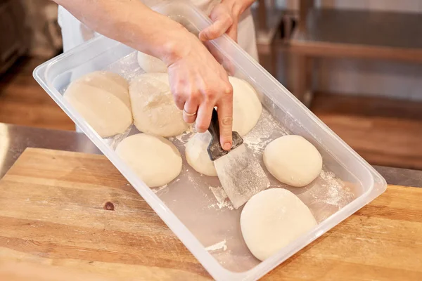 Бабки за неаполитанскую пиццу. Рука повара-пекаря в форме белого фартука готовит пиццу на кухне — стоковое фото