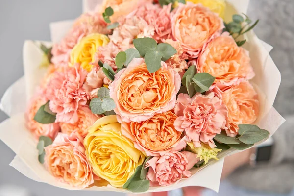 ヨーロッパの花屋だ。女性の手に混合花の美しい花束。花屋さんのお花屋さんの仕事。新鮮な切り花を配達する. — ストック写真