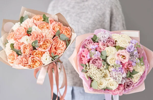 Dois belos buquês de flores mistas em mãos de mulheres. o trabalho da florista em uma loja de flores. Entrega flor de corte fresco. Loja floral europeia . — Fotografia de Stock
