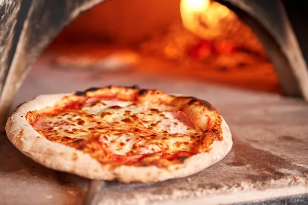 Gustosa pizza margherita al forno nel tradizionale forno a legna del ristorante napoletano. Pizza napoletana originale. Carbone caldo rosso . — Foto Stock