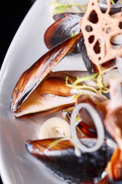 Lezzetli deniz ürünleri midyesi, roka ve soğanlı. Limon ve baget. Deniz kabuklarındaki istiridyeler. Restoran menüsü