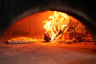 Napoli restoranında geleneksel ahşap fırında margherita pizza pişirdim. Orijinal Napoli pizzası. Kırmızı sıcak kömür.