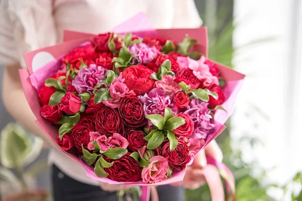 Tienda floral europea. Hermoso ramo de flores mixtas en manos de mujeres. el trabajo de la floristería en una florería. Entrega flor fresca cortada . —  Fotos de Stock