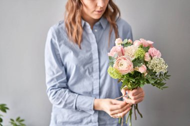 Çiçek dükkanı konsepti. Çiçekçi kadın çiçek aranjmanı yapar. Güzel bir buket karışık çiçek. Yakışıklılar. Çiçek teslimatı.