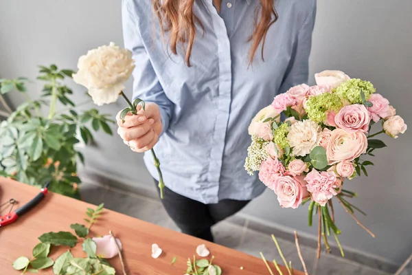 Vrouw bloemist het creëren van mooie boeket in de bloemenwinkel. Werken in de bloemenwinkel. Bloemen levering. — Stockfoto