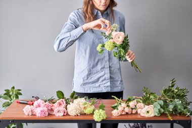 Çiçekçide çiçek buketi yapan kadın. Çiçekçide çalışıyorum. Çiçek teslimatı.