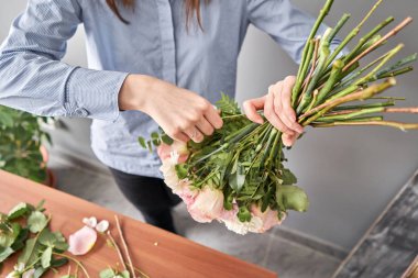 Çiçekçide çiçek buketi yapan kadın. Çiçekçide çalışıyorum. Çiçek teslimatı.