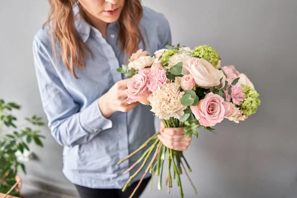 Concepto de tienda floral. Mujer florista crea arreglo floral. Hermoso ramo de flores mixtas. Hermoso grupo fresco. Entrega de flores . — Foto de Stock