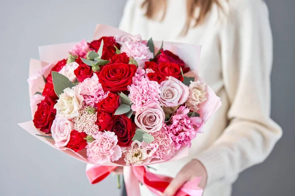 Європейський квітковий магазин. Червоний і рожевий прекрасний букет змішаних квітів у руках жінок. Робота квіткаря у квіткарні. Свіжа зрізана квітка.. — стокове фото