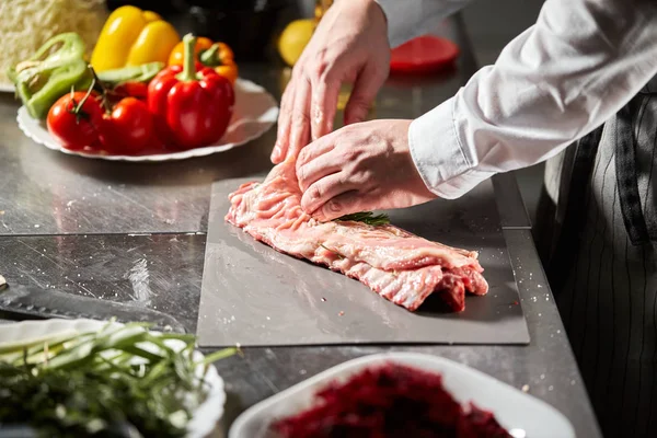 Costelas de cordeiro pronto para marinada com alecrim. Cozinhar com fogo na frigideira. Chef profissional em uma cozinha de cozinha de restaurante . — Fotografia de Stock