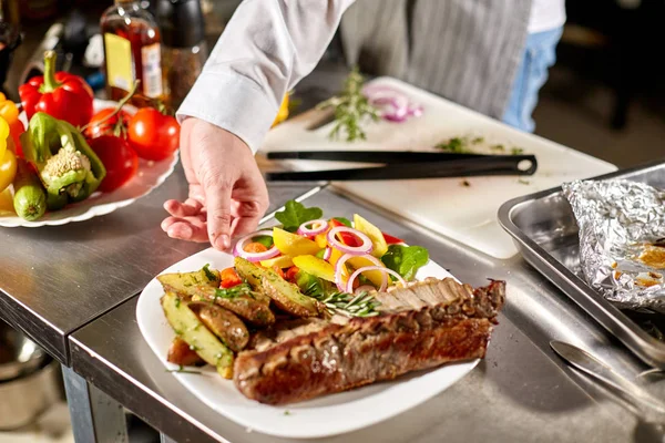 Egy rozmaring ágacska díszített. a séf készít az étteremben. Grillezett rack a Bárány sült burgonyával és friss zöldségek — Stock Fotó