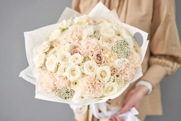 European floral shop. Beautiful bouquet of mixed flowers in womans hands. the work of the florist at a flower shop. Delivery fresh cut flower. — Stock Photo, Image