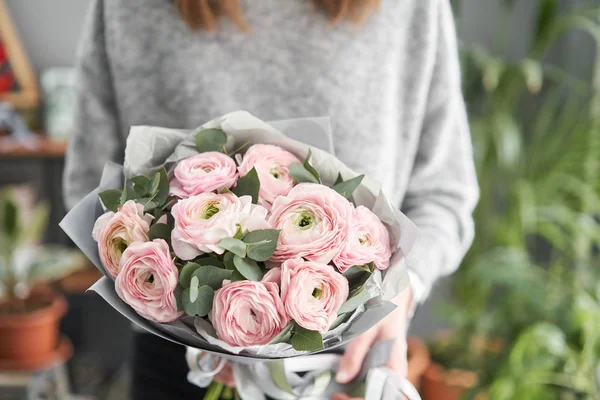 Bunch rosa pálido ranúnculo flores com eucalipto verde. O trabalho da florista em uma loja de flores. — Fotografia de Stock