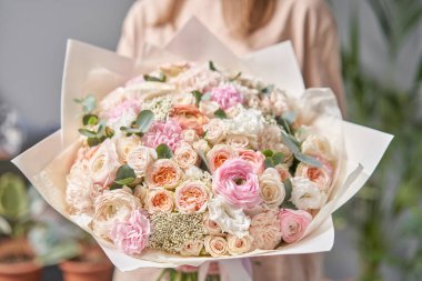 Avrupa çiçekçisi. Kadınların elinde güzel bir buket karışık çiçek. Çiçekçi dükkanındaki çiçekçinin işi. Taze kesilmiş çiçek getirdim..