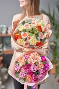 Kadınların elinde iki buket karışık çiçek var. Çiçekçi dükkanındaki çiçekçinin işi. Taze kesilmiş çiçek getirdim. Avrupa Çiçek Dükkanı.