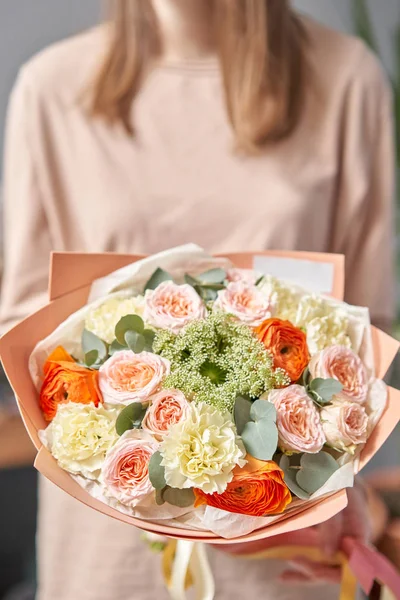 Negozio floreale europeo. Bellissimo bouquet di fiori misti nelle mani delle donne. il lavoro del fioraio in un negozio di fiori. Consegna fresco fiore reciso . — Foto Stock