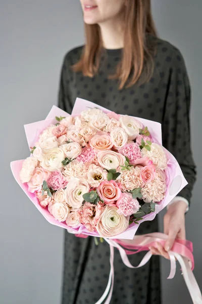 Tienda floral europea. Hermoso ramo de flores mixtas en manos de mujeres. el trabajo de la floristería en una florería. Entrega flor fresca cortada . — Foto de Stock