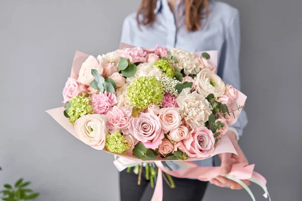 Tienda floral europea. Hermoso ramo de flores mixtas en manos de mujeres. el trabajo de la floristería en una florería. Entrega flor fresca cortada . — Foto de Stock